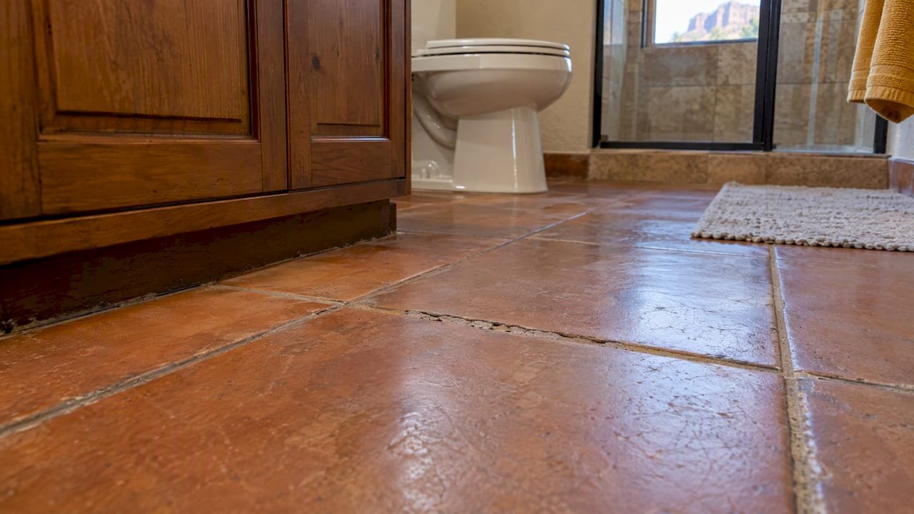 Worn grout between terracotta rental bathroom tiles